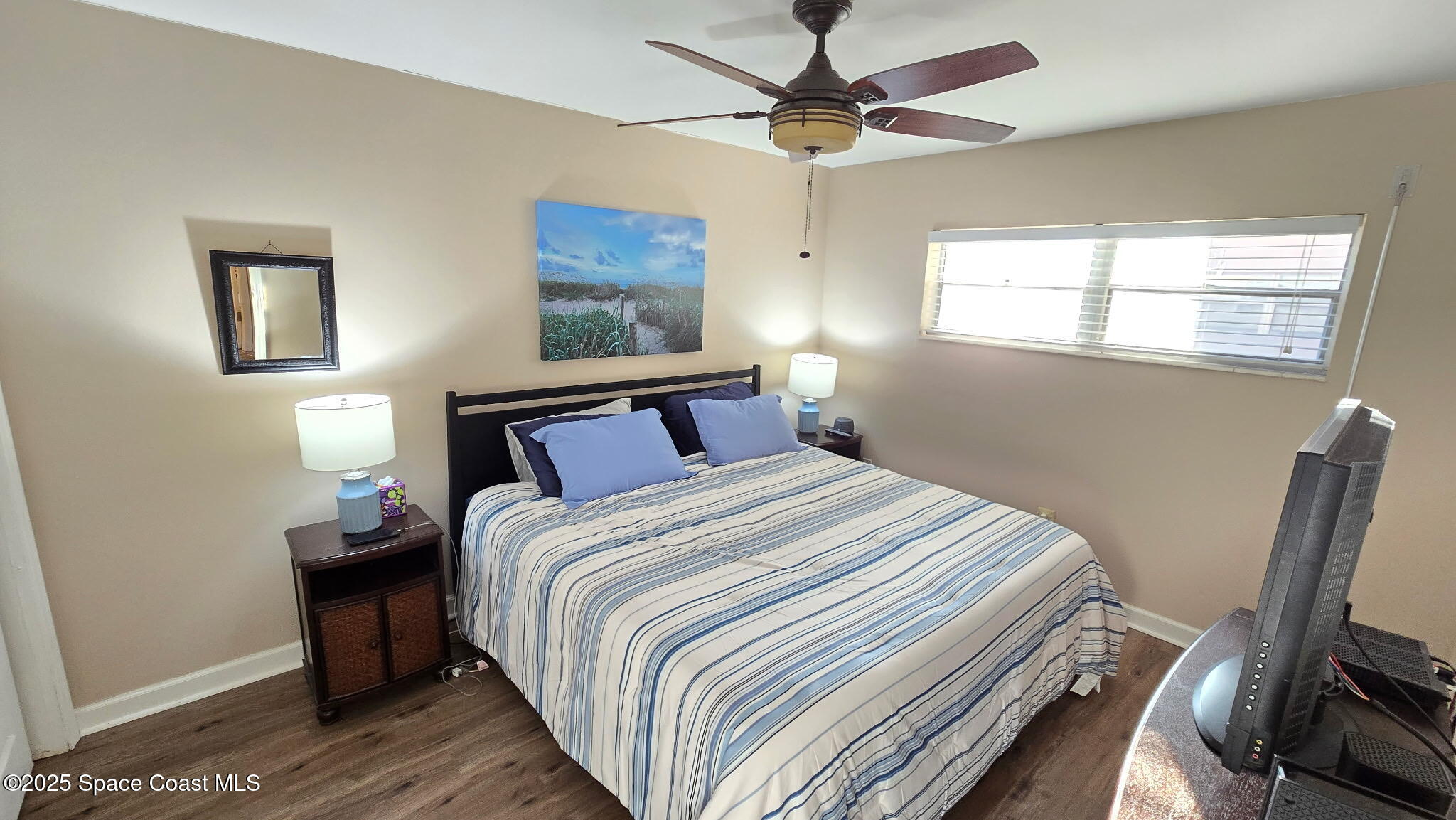 3150 North Atlantic Avenue, Unit 1770 Cocoa Beach, FL 32931 - Photo 8 of 21 a bedroom with a bed and wooden floor