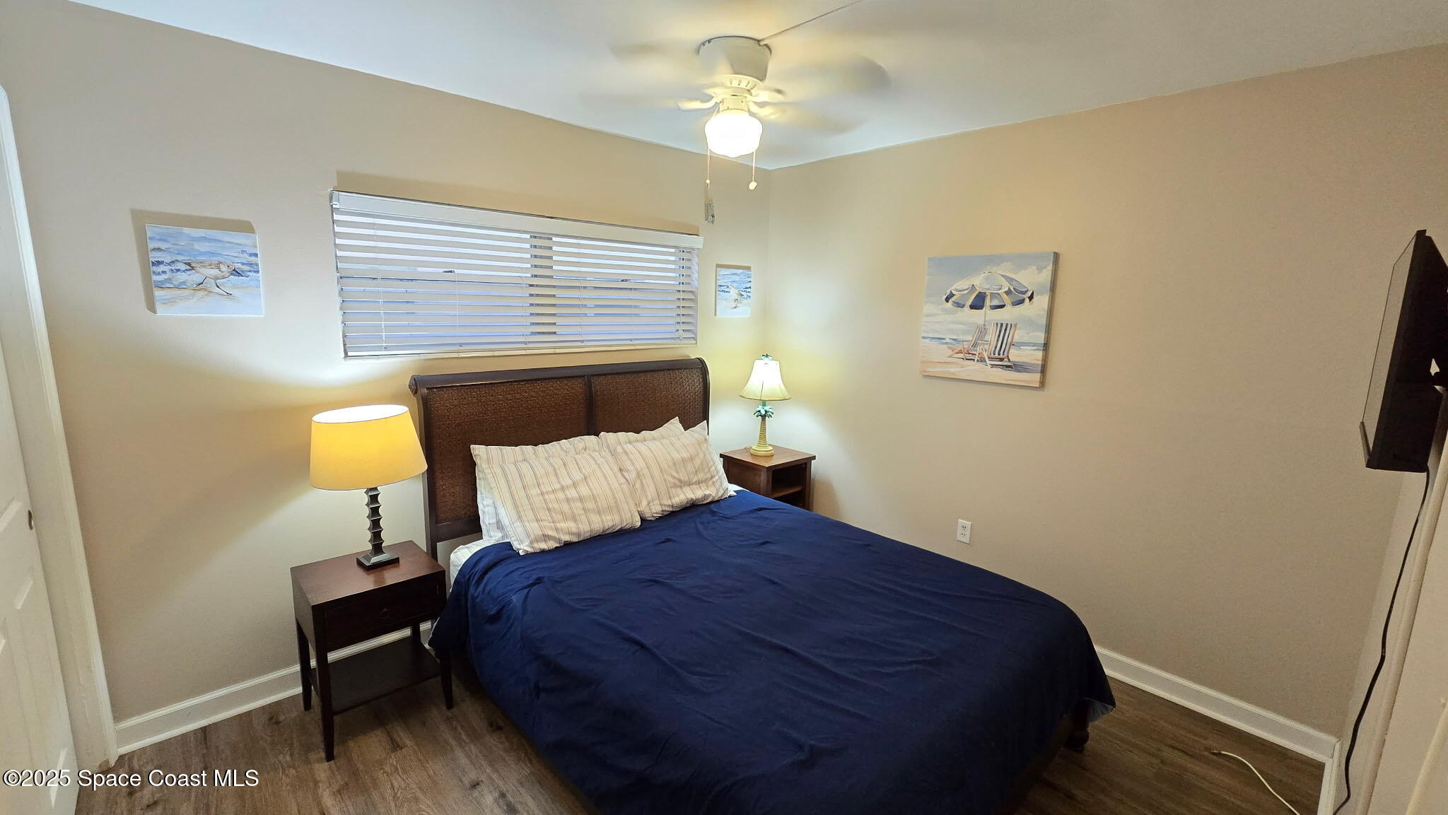 3150 North Atlantic Avenue, Unit 1770 Cocoa Beach, FL 32931 - Photo 10 of 21 a bedroom with a bed and a chandelier