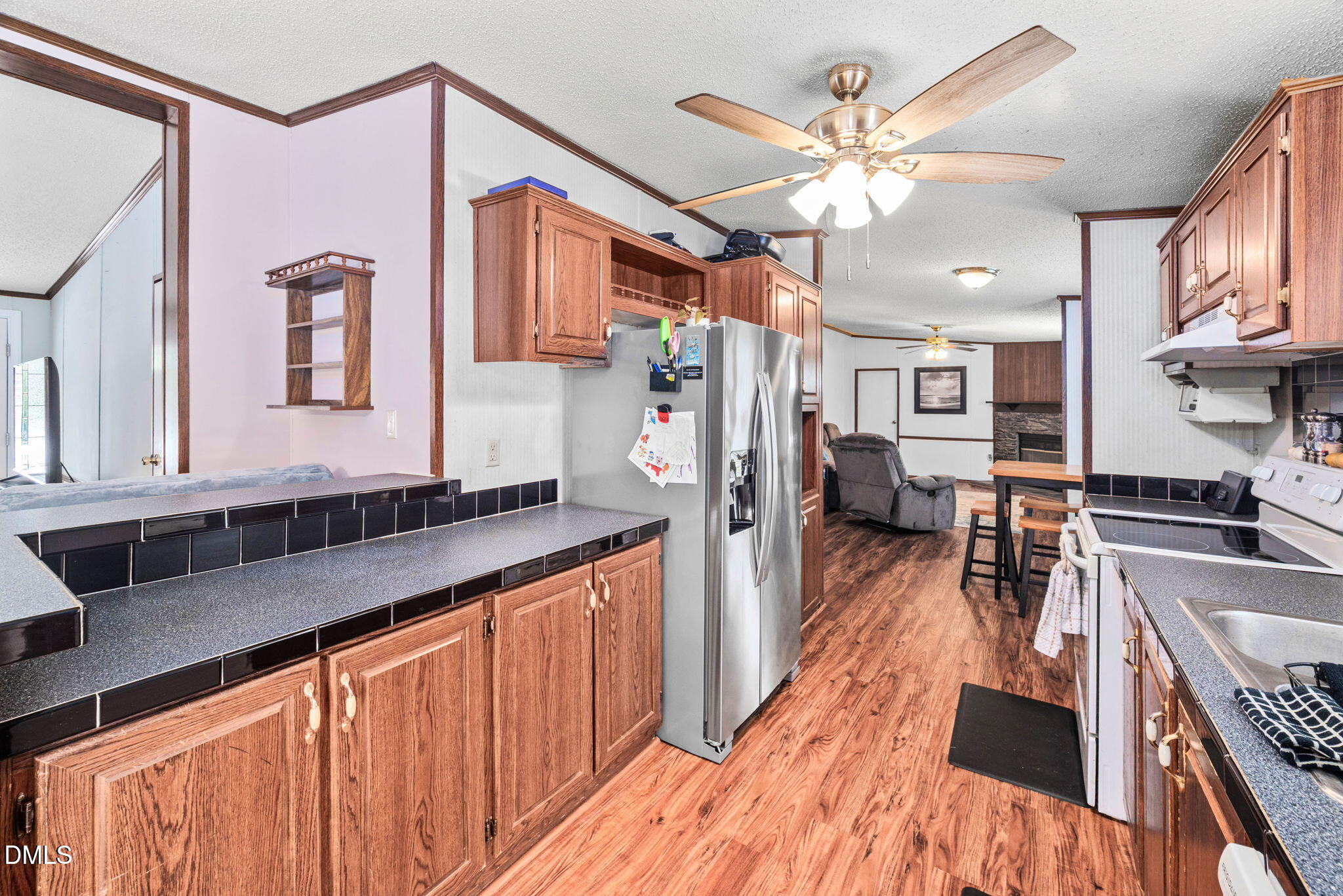 2005 Mooregate Court Clayton, NC 27520 - Photo 8 of 31 a kitchen with stainless steel appliances granite countertop a refrigerator a sink dishwasher a dining table and chairs with wooden floor