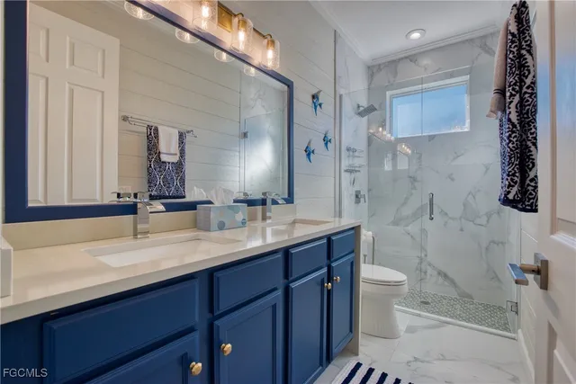 a bathroom with a double vanity sink toilet mirror and shower