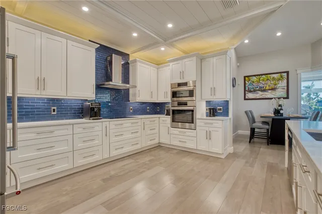 a large white kitchen with cabinets