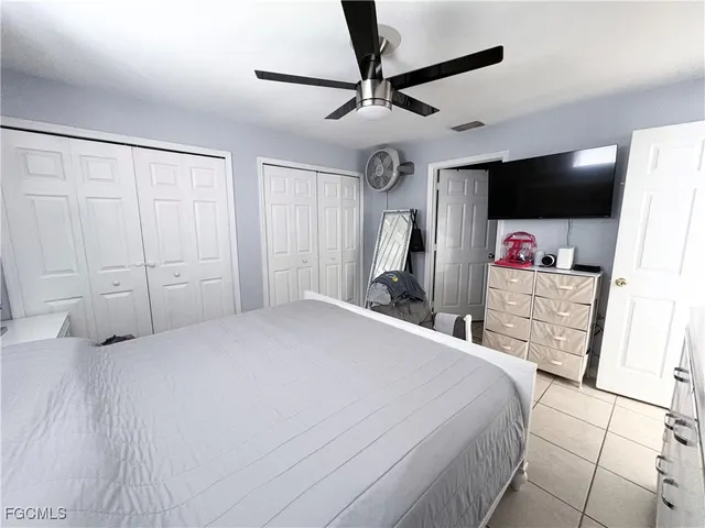 a bedroom with a bed a mirror and a flat screen tv