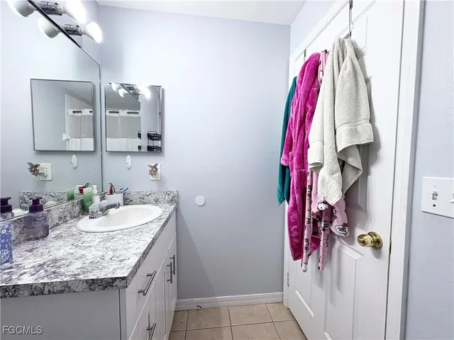 a bathroom with a granite countertop sink vanity and tub