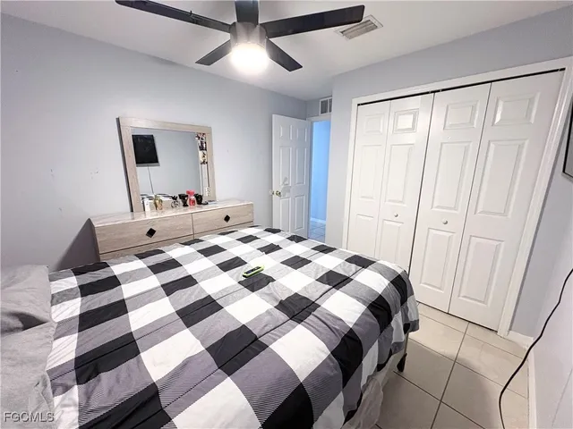 a bedroom with a bed and a mirror on a dresser