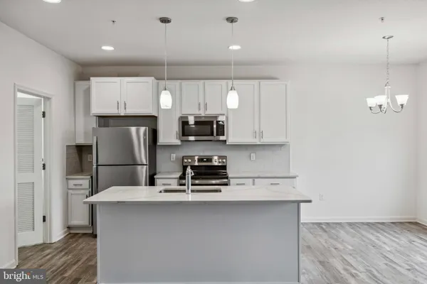 a kitchen with stainless steel appliances a refrigerator a sink a stove a microwave and island