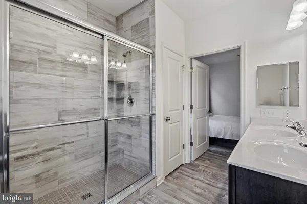 an empty room with wooden floor cabinet and windows