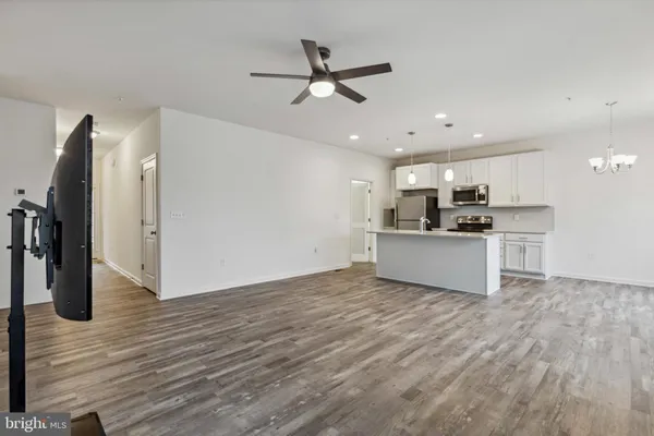 a view of a kitchen with wooden floor and a ceiling fan