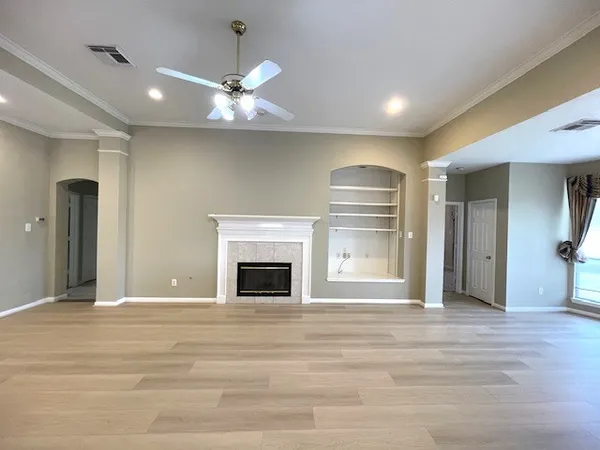 a view of an empty room with a fireplace and a window