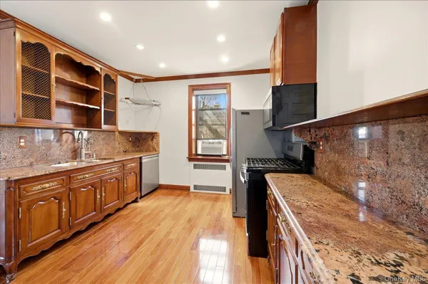 a kitchen with stainless steel appliances granite countertop a stove a sink and a microwave