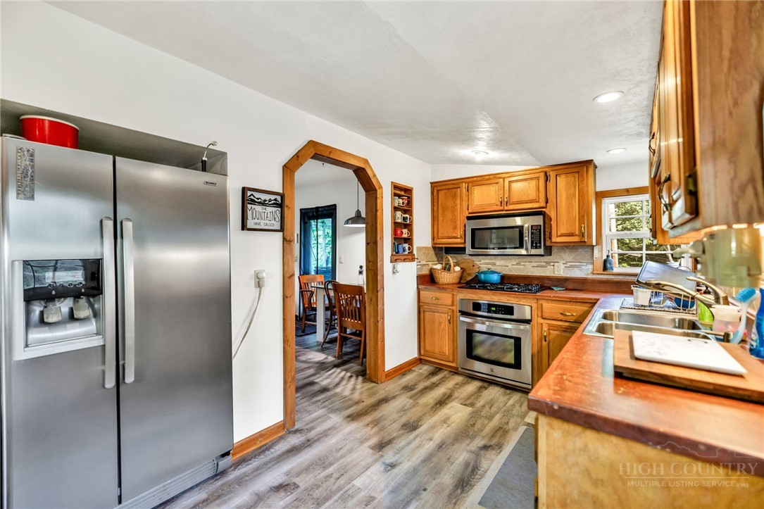 242 Ladd Parson Road Crumpler, NC 28617 - Photo 14 of 36 a kitchen with stainless steel appliances granite countertop a refrigerator a stove and a sink