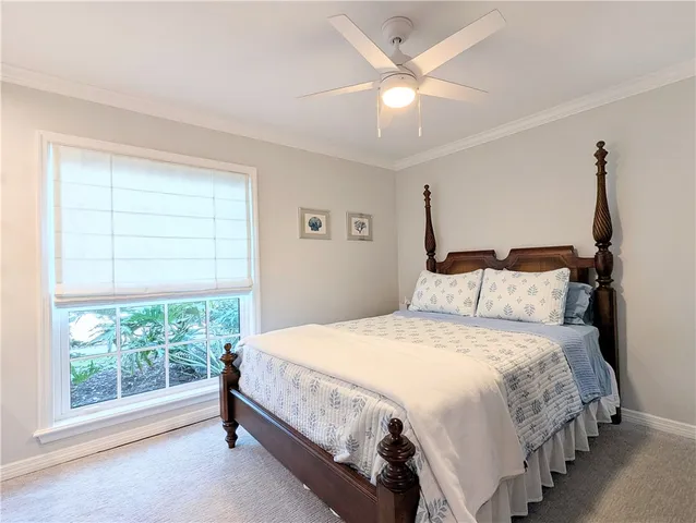 a bedroom with a bed chandelier and a window