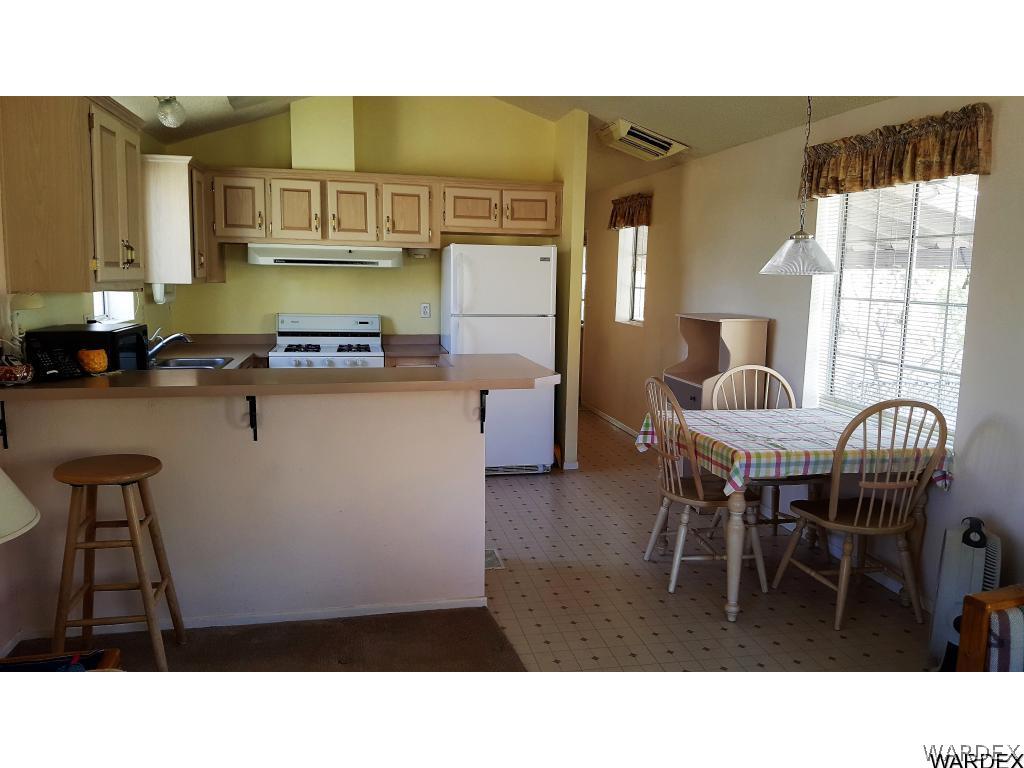 3256 South Tennessee Road Golden Valley, AZ 86413 - Photo 36 of 36 a kitchen with a dining table chairs and granite counter tops