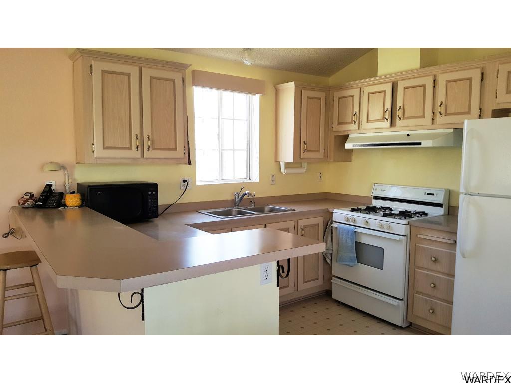 3256 South Tennessee Road Golden Valley, AZ 86413 - Photo 9 of 36 a kitchen with a stove a sink and a refrigerator
