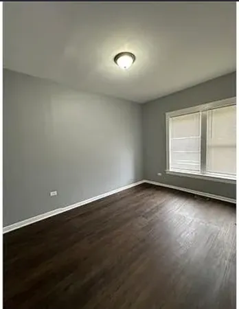 a view of a livingroom with wooden floor and window