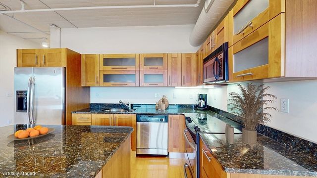 a kitchen with stainless steel appliances granite countertop a sink and a stove