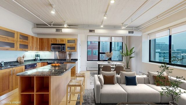 a living room with stainless steel appliances granite countertop furniture and a kitchen view