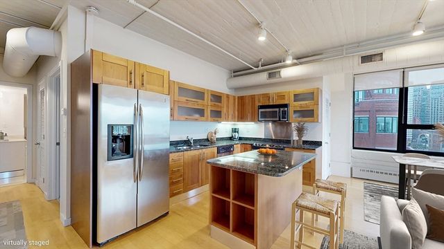 a kitchen with stainless steel appliances granite countertop a refrigerator a stove and a sink