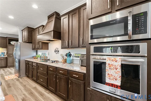 a kitchen with stainless steel appliances granite countertop a stove microwave and sink