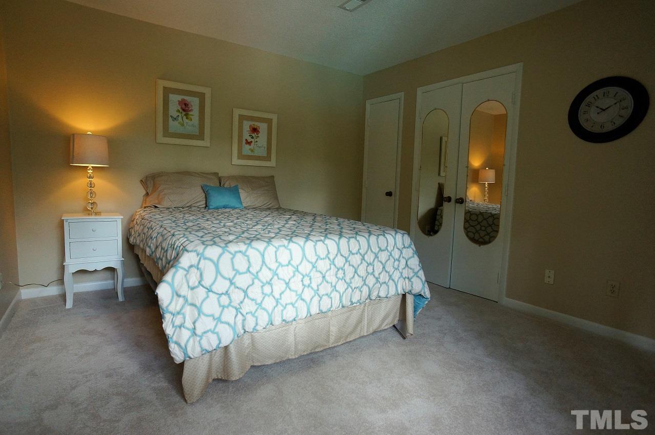 618 Pine Ridge Place, Unit 618 Raleigh, NC 27609 - Photo 13 of 20 a bedroom with a bed and a chandelier