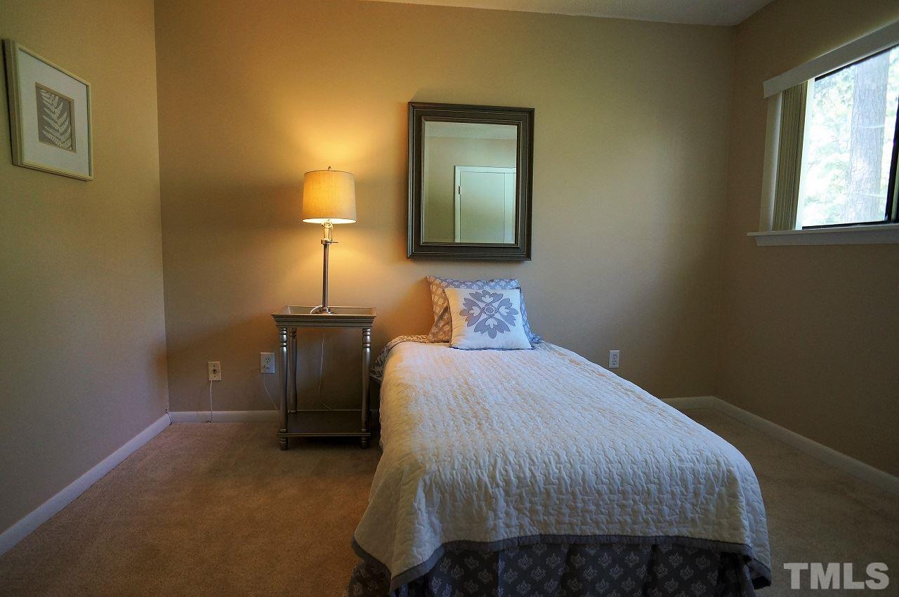618 Pine Ridge Place, Unit 618 Raleigh, NC 27609 - Photo 14 of 20 a bedroom with a bed and a lamp