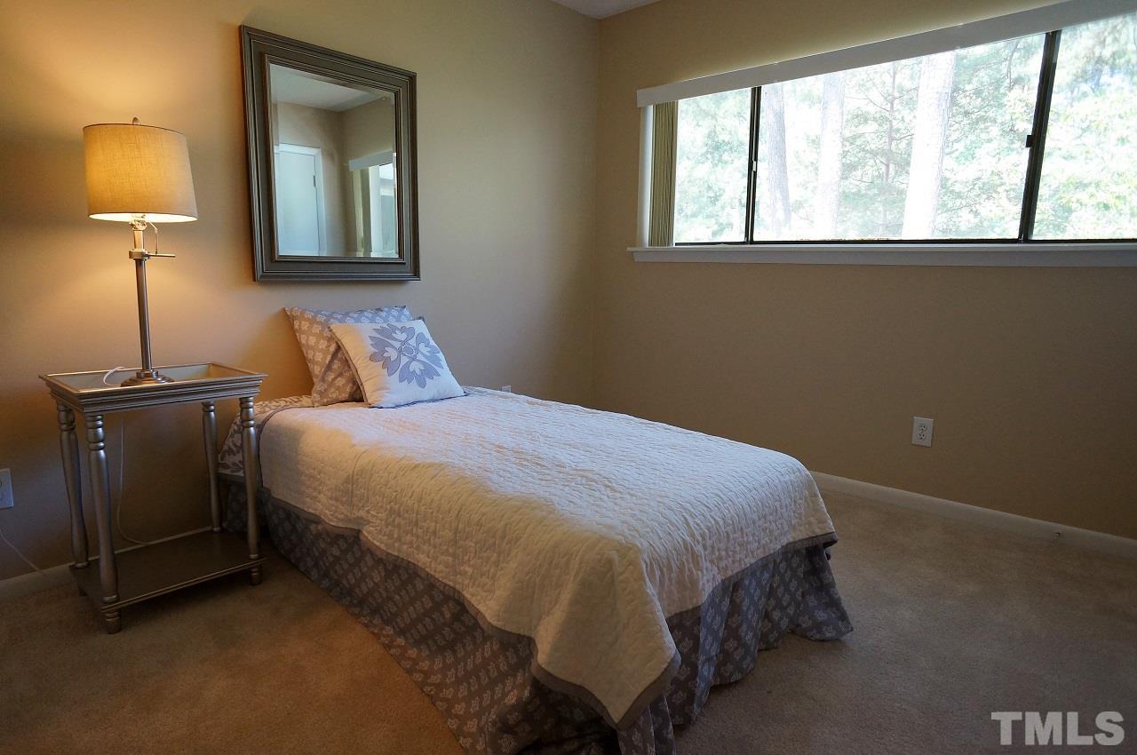 618 Pine Ridge Place, Unit 618 Raleigh, NC 27609 - Photo 15 of 20 a bedroom with a bed and a lamp