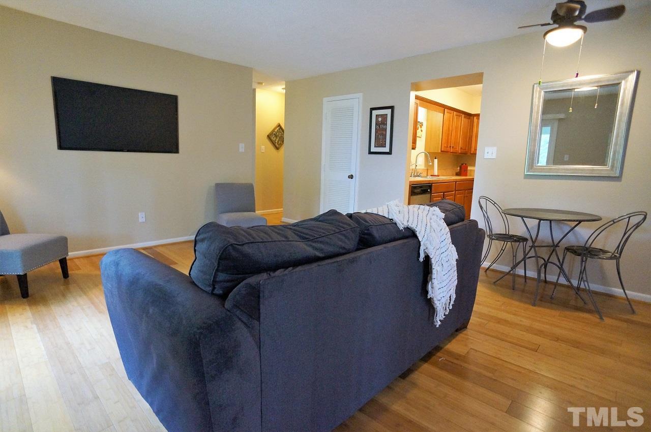 618 Pine Ridge Place, Unit 618 Raleigh, NC 27609 - Photo 8 of 20 a living room with couches and a flat screen tv with wooden floor