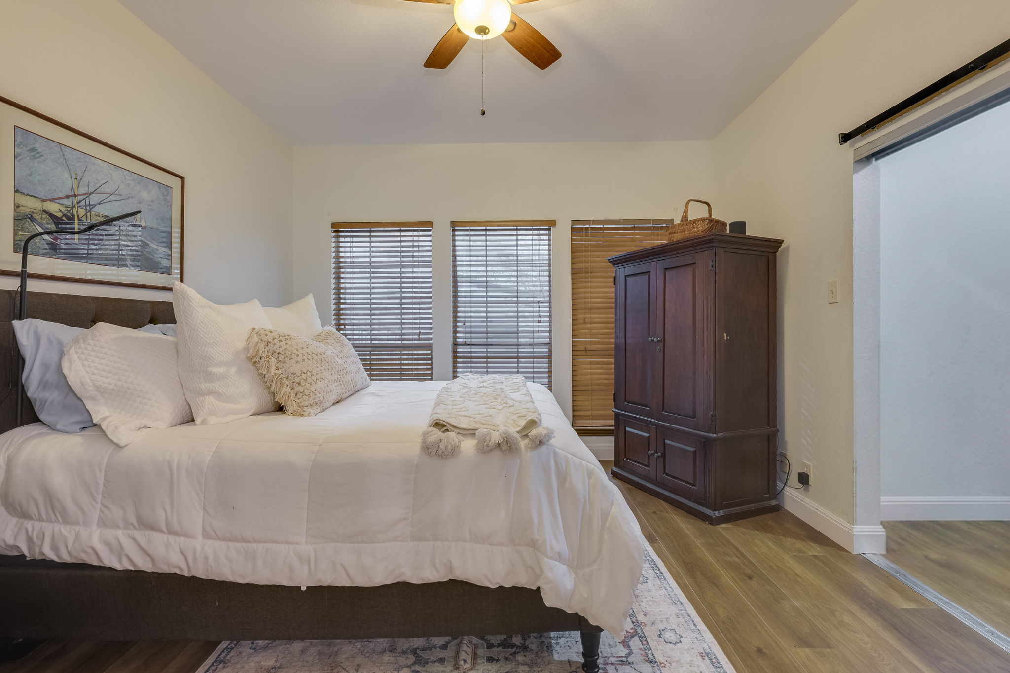 3809 Spicewood Springs Road, Unit 150 Austin, TX 78759 - Photo 24 of 35 a bedroom with a bed dresser and wooden floor