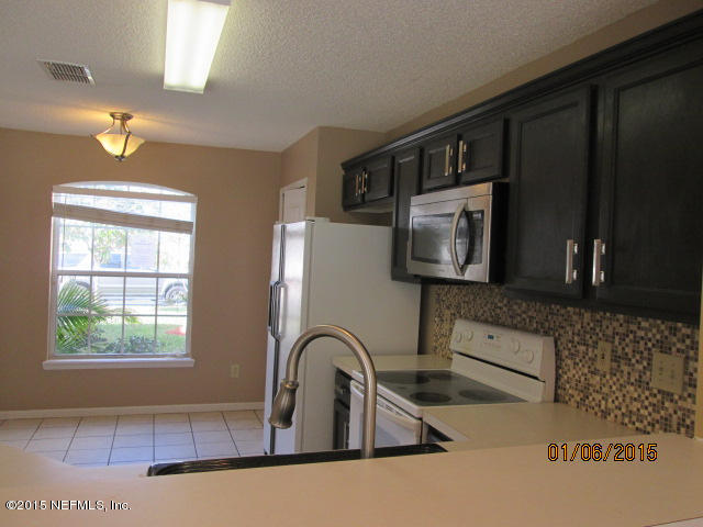 705 South Covered Bridge Road, Unit 2 St. Johns, FL 32259 - Photo 4 of 13 a kitchen with a sink a window and stainless steel appliances