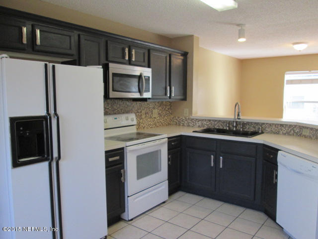 705 South Covered Bridge Road, Unit 2 St. Johns, FL 32259 - Photo 5 of 13 a kitchen with stainless steel appliances granite countertop a refrigerator and a stove top oven