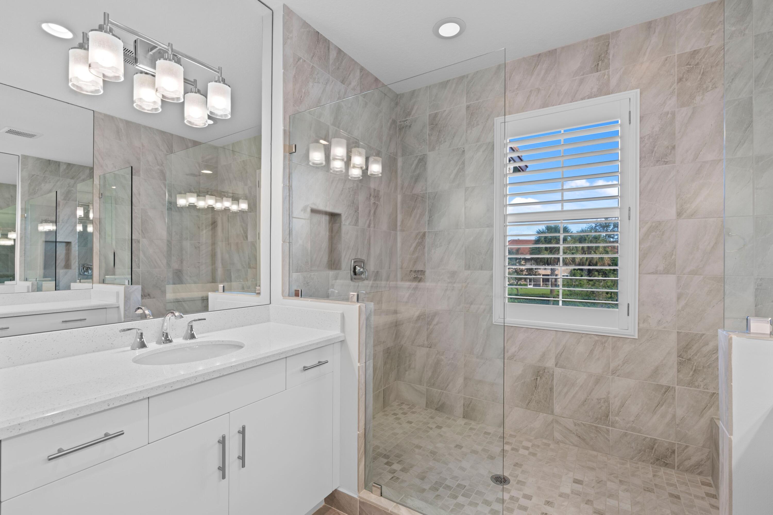 6693 Quiet Wave Trail, Unit 41 Boca Raton, FL 33433 - Photo 13 of 40 a bathroom with a sink a mirror and a shower