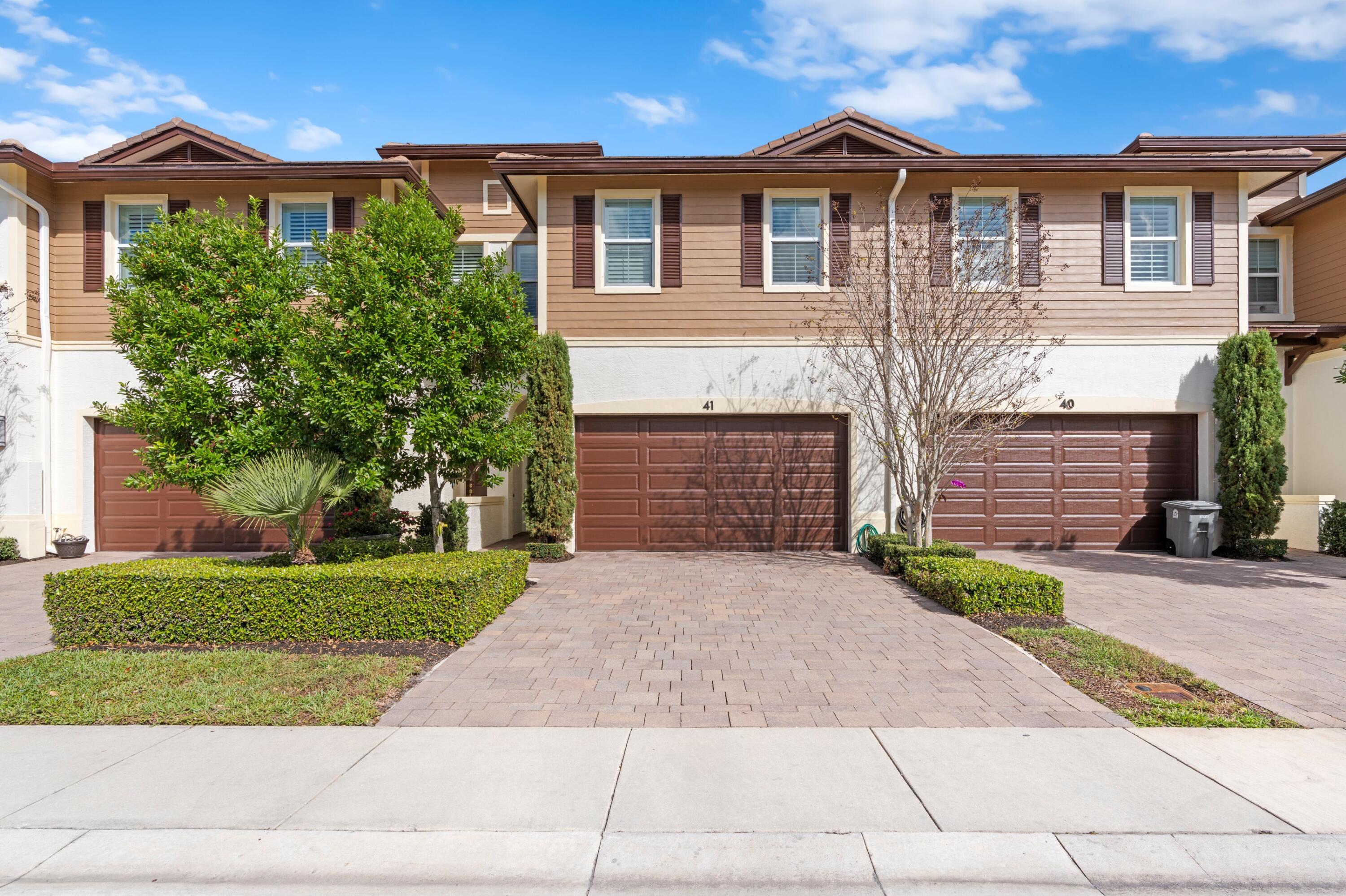 6693 Quiet Wave Trail, Unit 41 Boca Raton, FL 33433 - Photo 21 of 40 a front view of a house with a yard and a garage