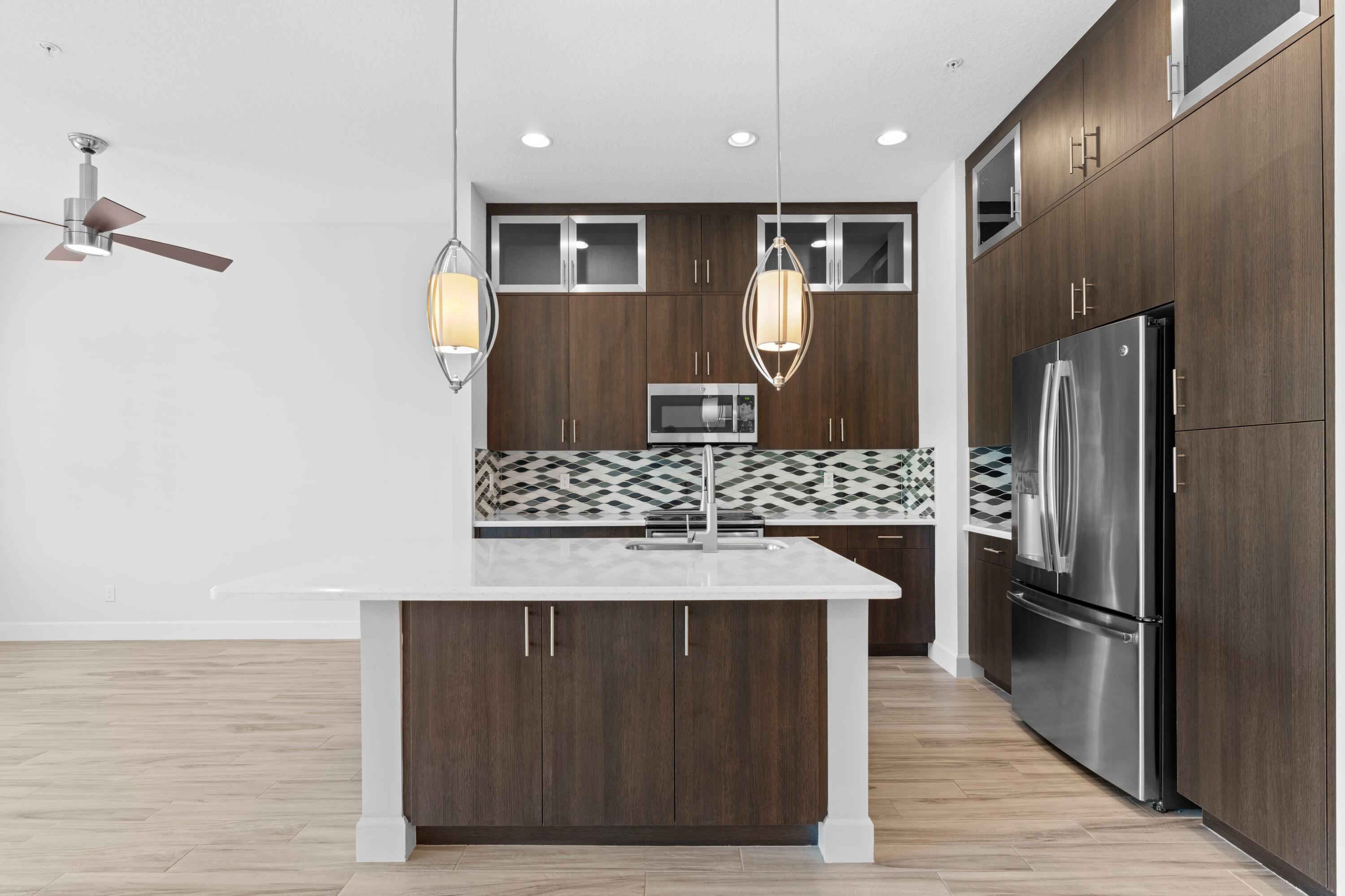 6693 Quiet Wave Trail, Unit 41 Boca Raton, FL 33433 - Photo 5 of 40 a kitchen with stainless steel appliances granite countertop a refrigerator and a stove
