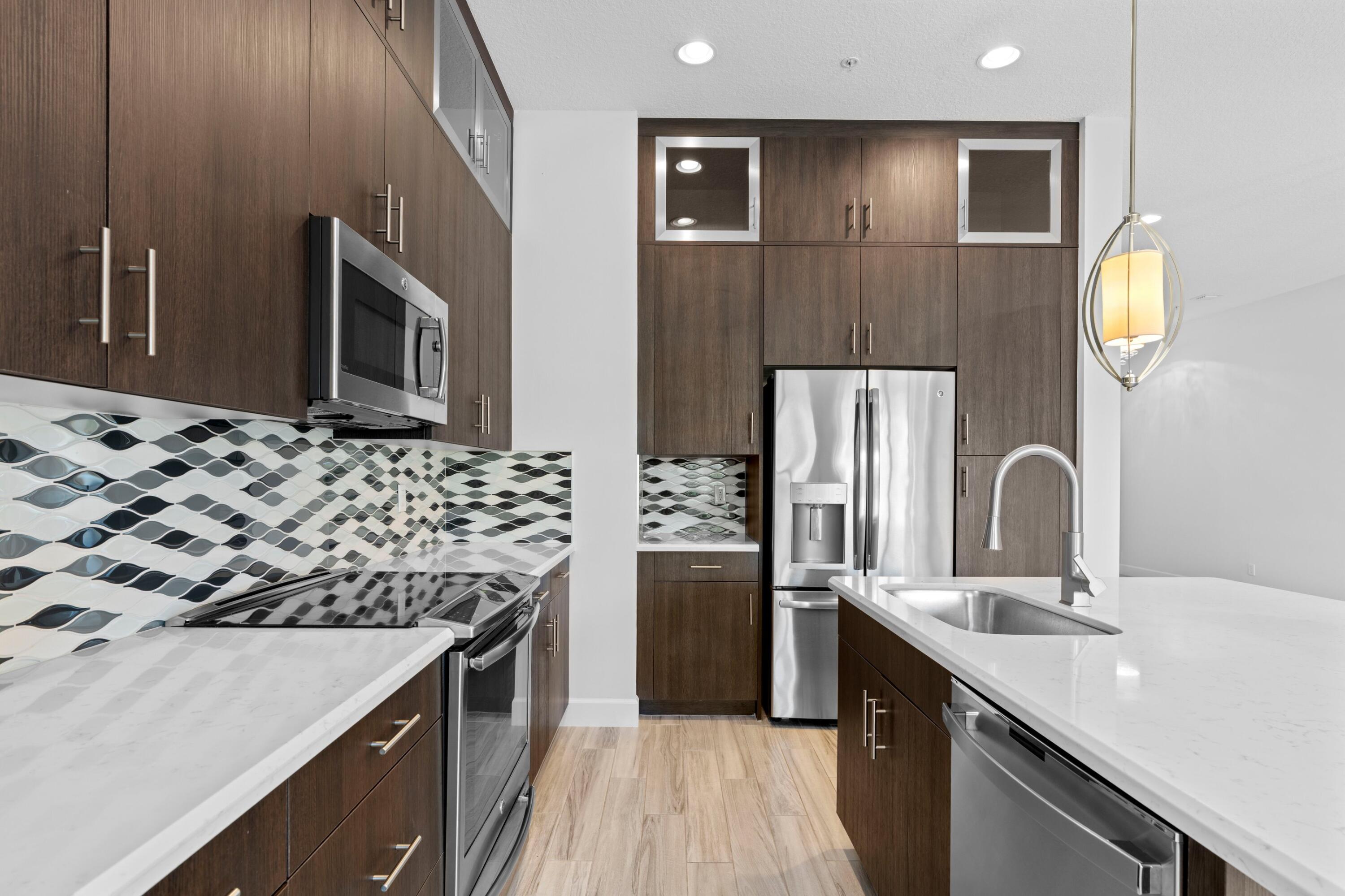 6693 Quiet Wave Trail, Unit 41 Boca Raton, FL 33433 - Photo 6 of 40 a kitchen with stainless steel appliances a sink stove and refrigerator