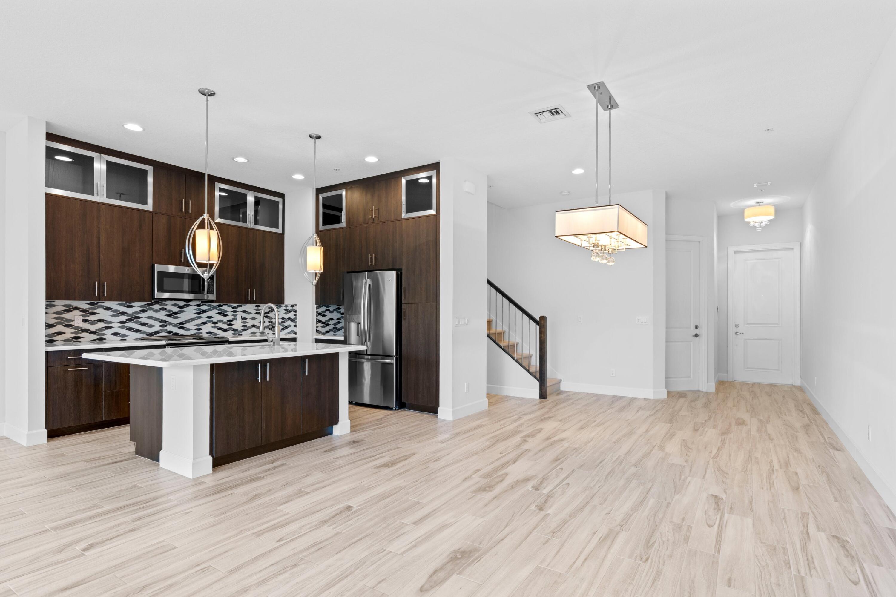 6693 Quiet Wave Trail, Unit 41 Boca Raton, FL 33433 - Photo 9 of 40 a kitchen with stainless steel appliances granite countertop a stove and a wooden floors