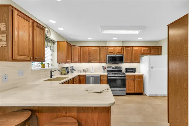 a kitchen with stainless steel appliances granite countertop a refrigerator and a stove top oven