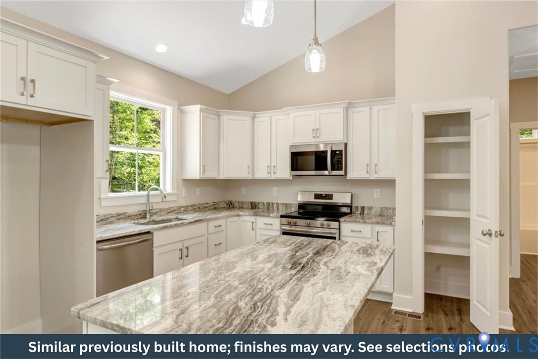 126 Firetower Lane Keysville, VA 23947 - Photo 5 of 18 a kitchen with stainless steel appliances granite countertop a stove top oven a sink a counter space and cabinets