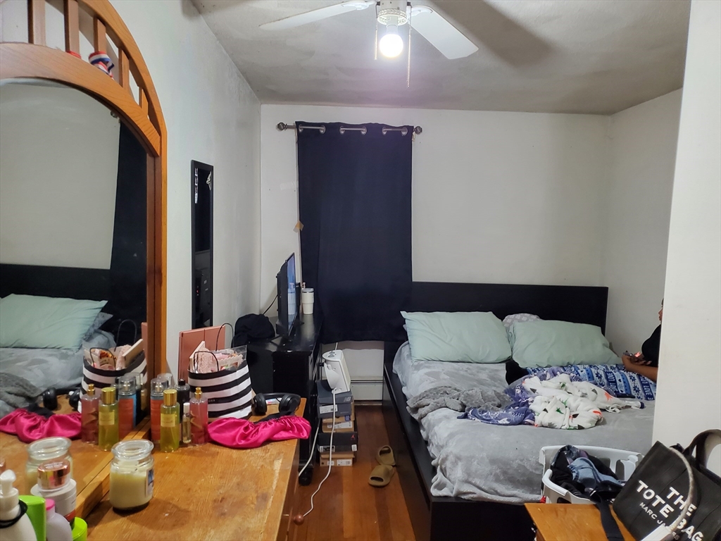10-12 Carnes Street Lynn, MA 01905 - Photo 15 of 21 a bedroom with bed and a potted plant