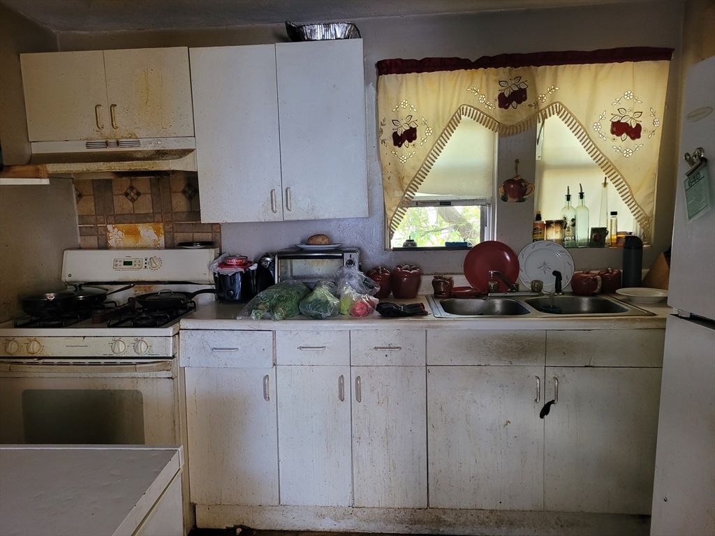 10-12 Carnes Street Lynn, MA 01905 - Photo 18 of 21 a kitchen with stainless steel appliances granite countertop a stove a sink and a microwave