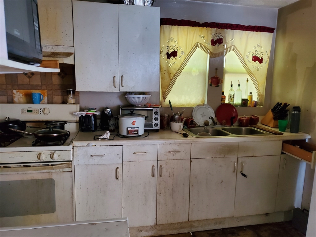 10-12 Carnes Street Lynn, MA 01905 - Photo 5 of 21 a kitchen with cabinets and appliances