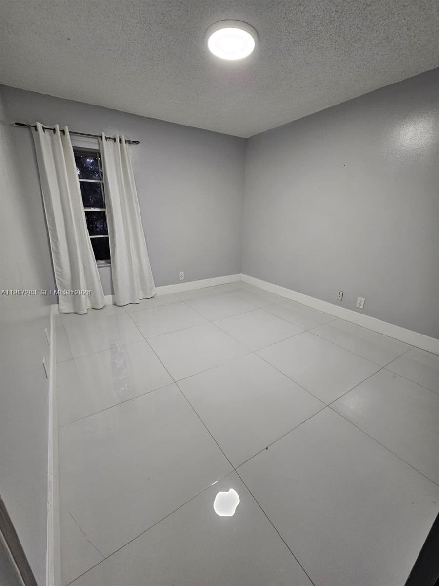 8003 Southwest 158th Place Miami, FL 33193 - Photo 14 of 20 an empty room with staircase and white walls