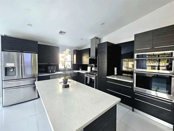 a kitchen with granite countertop a refrigerator stove and oven