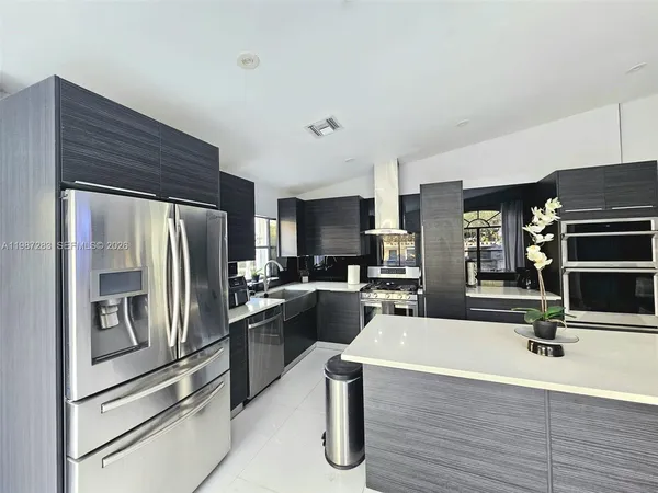 a kitchen with kitchen island a counter top space stainless steel appliances and cabinets