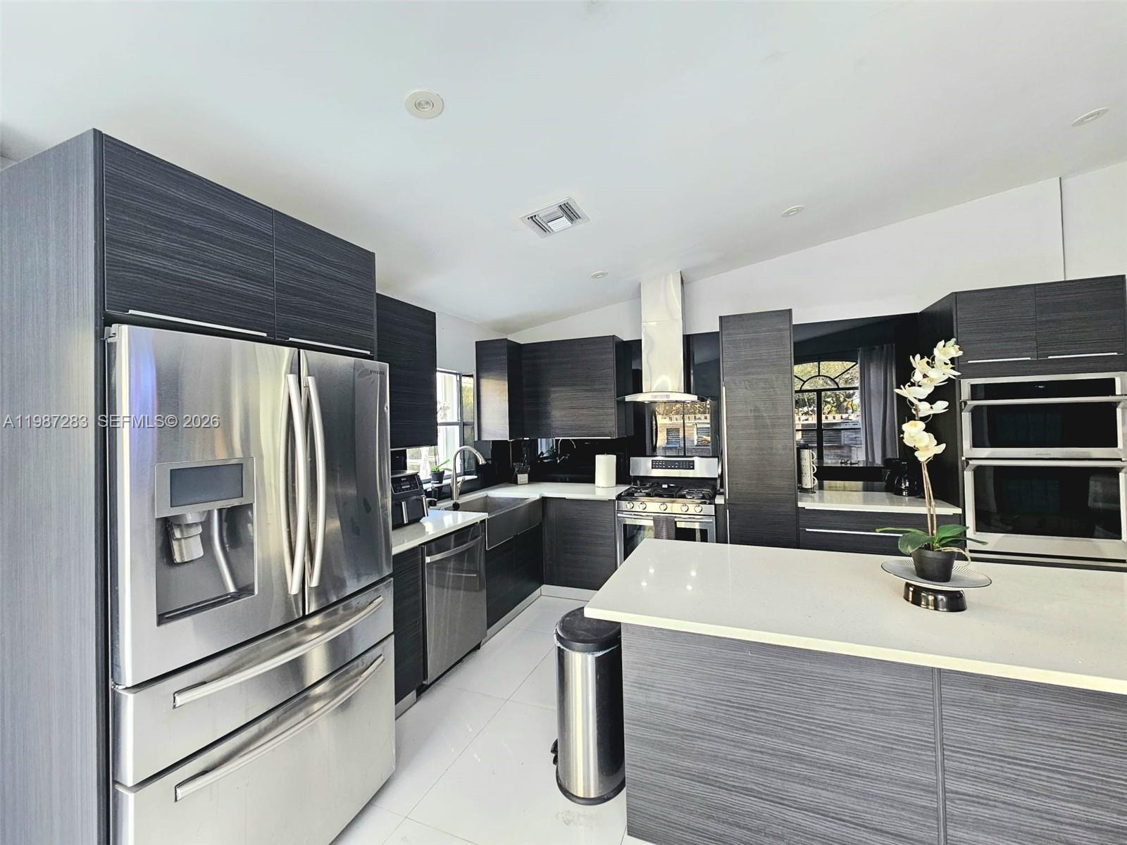 8003 Southwest 158th Place Miami, FL 33193 - Photo 6 of 20 a kitchen with kitchen island a counter top space stainless steel appliances and cabinets