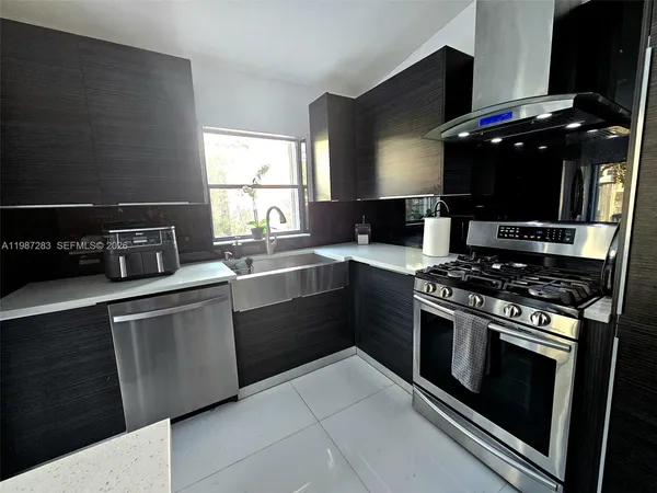 a kitchen with stainless steel appliances a stove a sink and a microwave