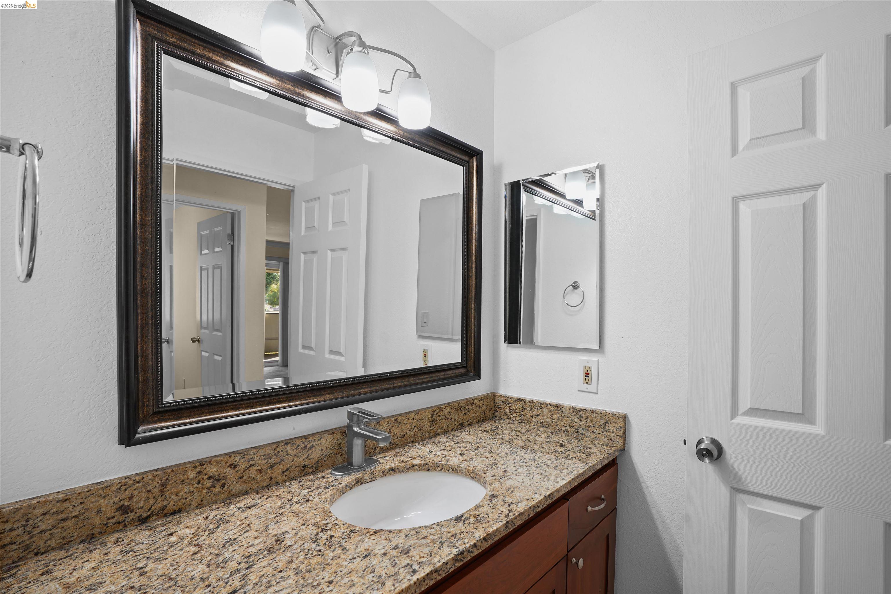 1505 Kirker Pass Road, Unit 214 Concord, CA 94521 - Photo 39 of 55 Bathroom vanity featuring a light-toned granite countertop, under-mount sink, and contemporary brushed nickel faucet