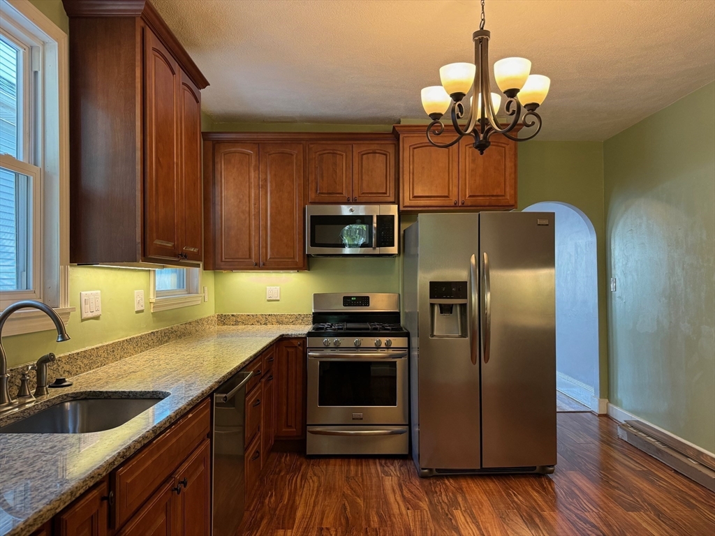 59 Centre Street, Unit PH Boston, MA 02124 - Photo 1 of 13 a kitchen with granite countertop stainless steel appliances a sink cabinets and wooden floor
