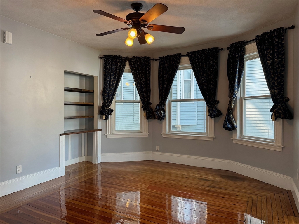 59 Centre Street, Unit PH Boston, MA 02124 - Photo 3 of 13 a view of an empty room with a window and wooden floor