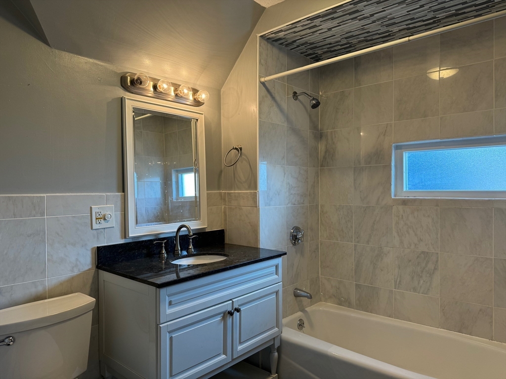 59 Centre Street, Unit PH Boston, MA 02124 - Photo 7 of 13 a bathroom with a granite countertop sink a toilet and shower