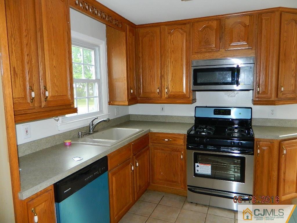 678 Ridge Road Monmouth Junction, NJ 08852 - Photo 3 of 9 a kitchen with granite countertop a stove top oven microwave and cabinets