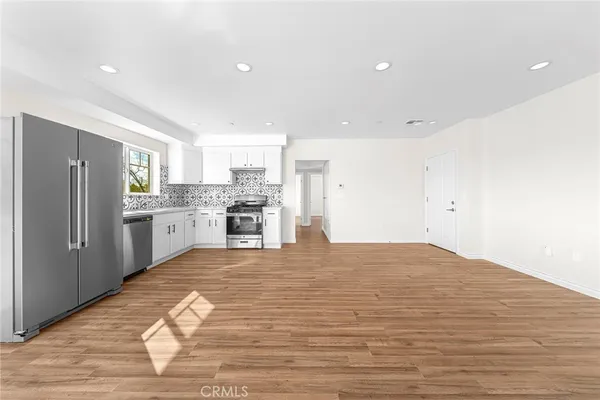 a kitchen with stainless steel appliances granite countertop a stove a refrigerator and a stove